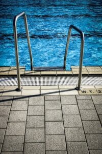 Pressure Washing Gallery a close up of a poolside ladder with pool on top and the pavement on the bottom